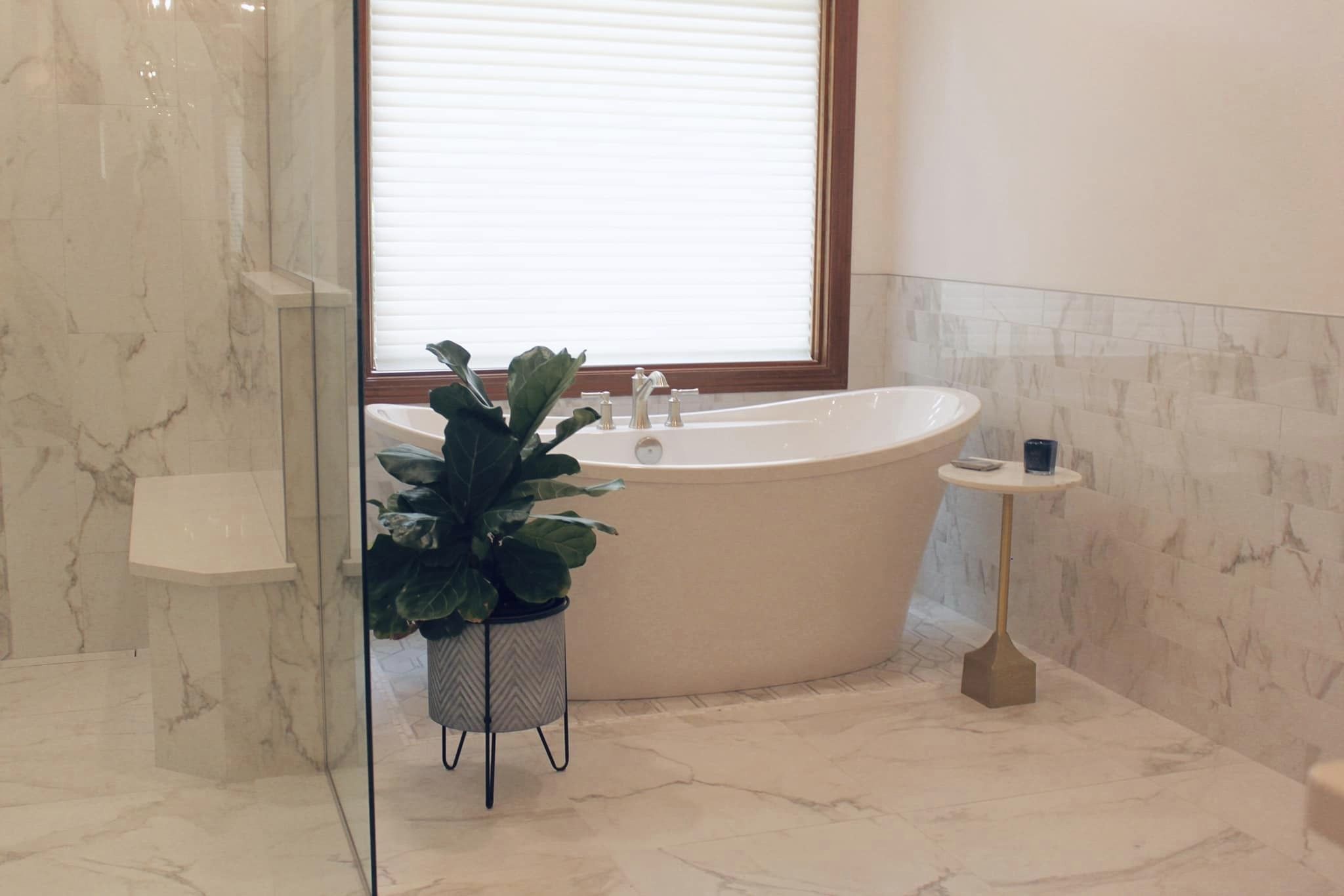 Luxurious marble bathroom with freestanding tub by the window.